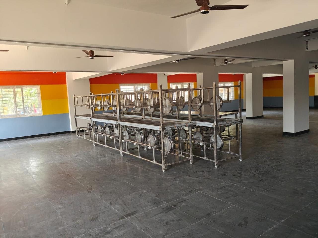 Canteen dining tables stacked in a large hall before layout