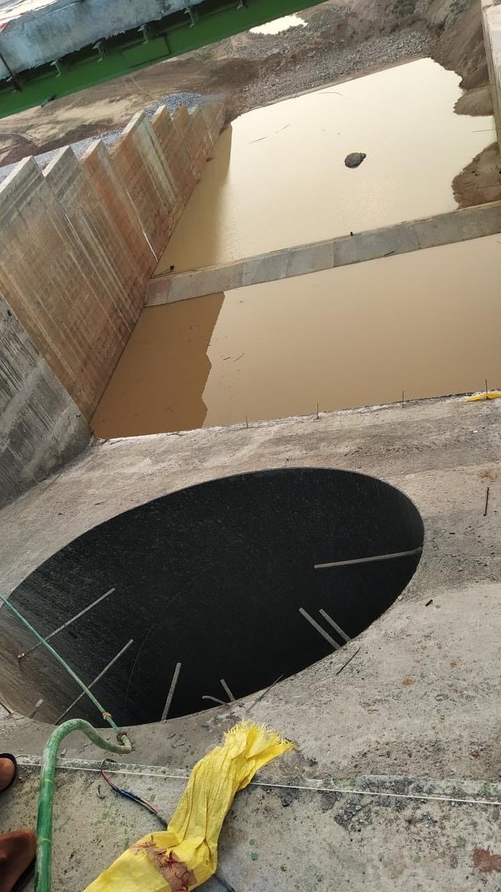 Looking down into a deep circular opening beside water