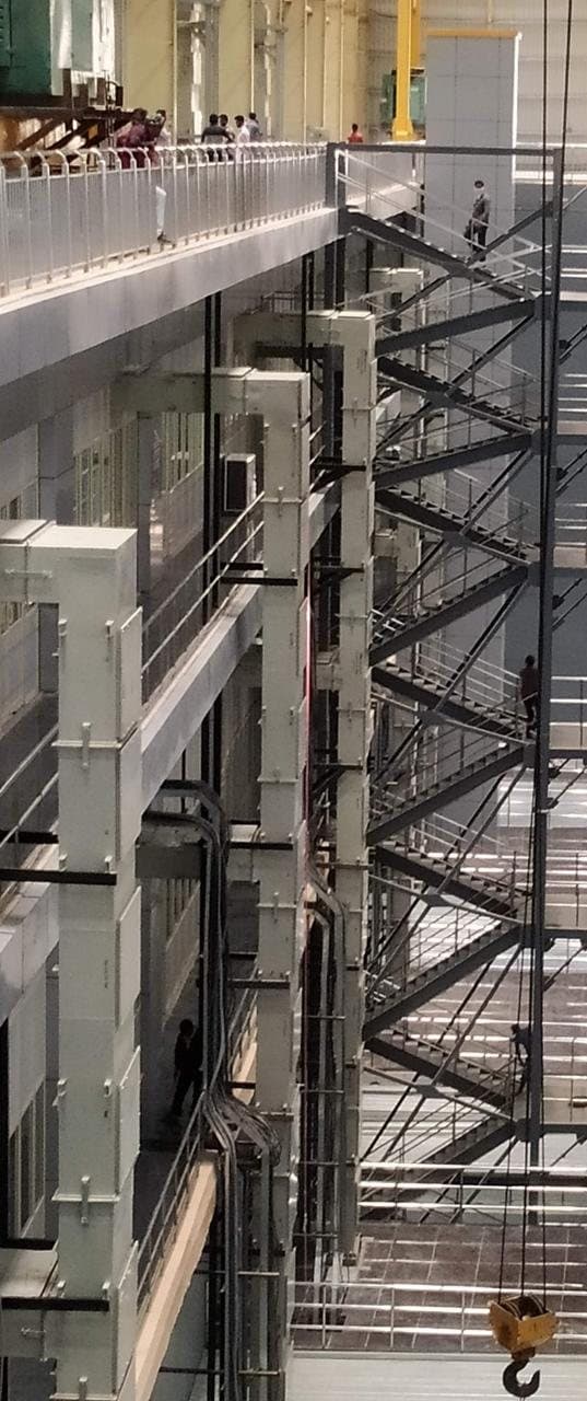 Multi-level steel staircase with railings inside the pump house